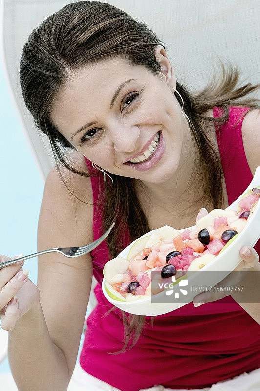 一个年轻女人拿着碗里的食物的肖像图片素材