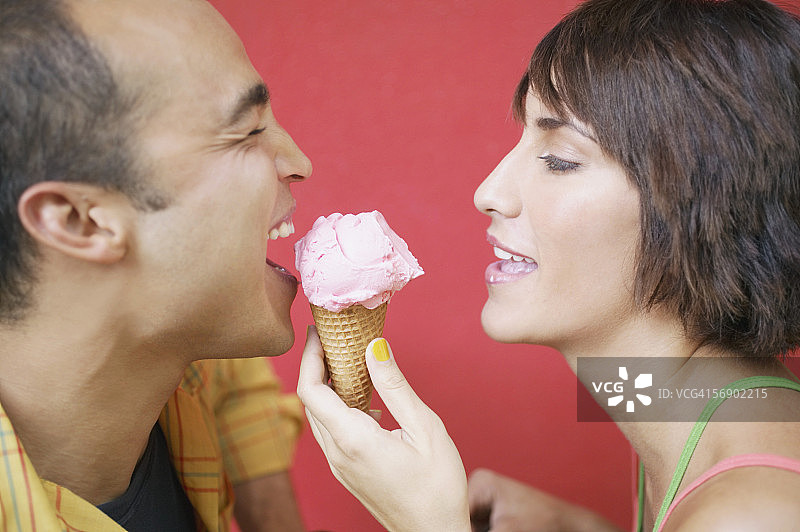 夫妻分享冰淇淋蛋卷的侧面视图图片素材