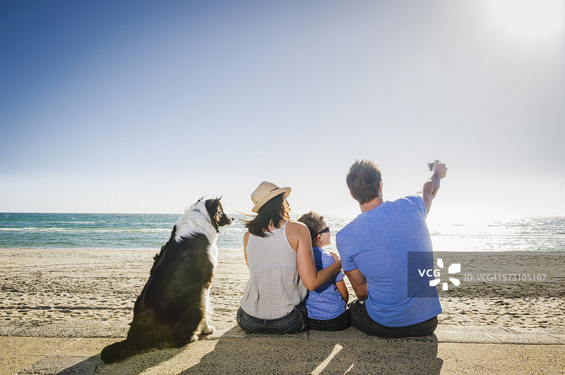白人家庭与狗在海滩上自拍图片素材
