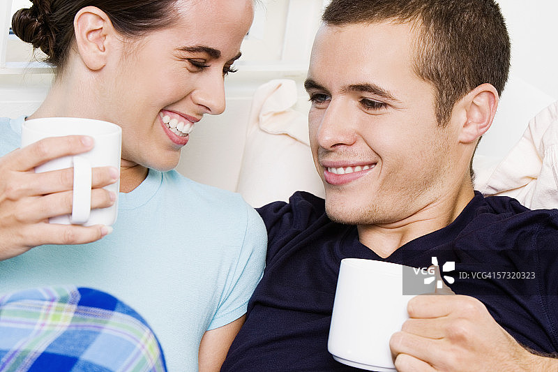 一对年轻夫妇拿着咖啡杯的特写图片素材