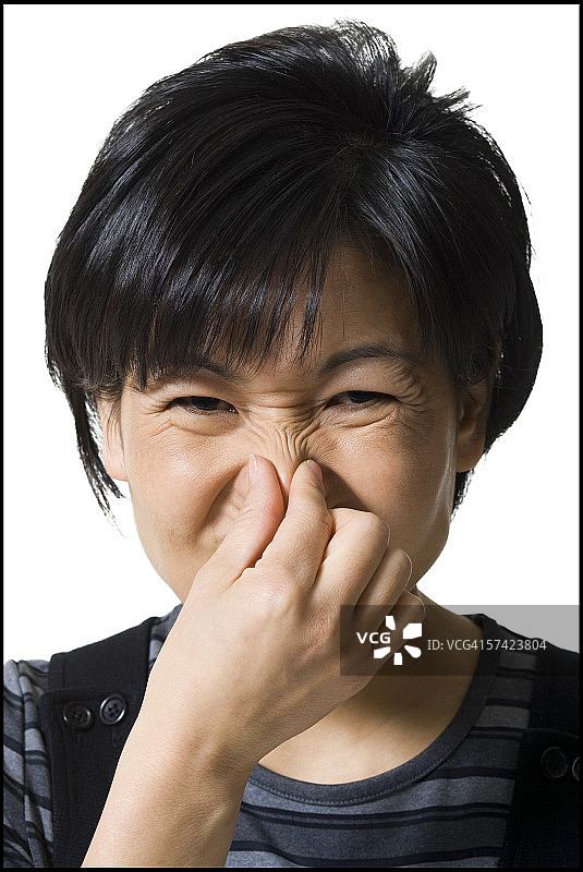 一个成年妇女捏着鼻子的肖像图片素材