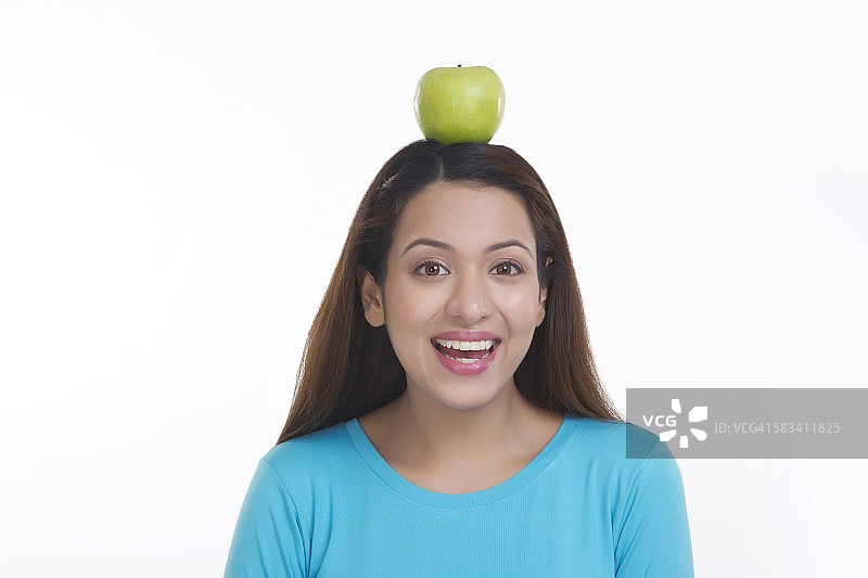 女人头上顶着苹果的肖像图片素材