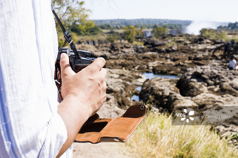 一名男子在赞比亚维多利亚瀑布附近使用相机拍摄的片断图片素材