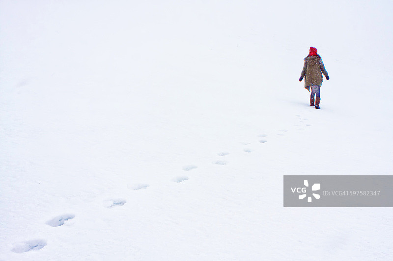 一位女士走在洁白的雪地上图片素材