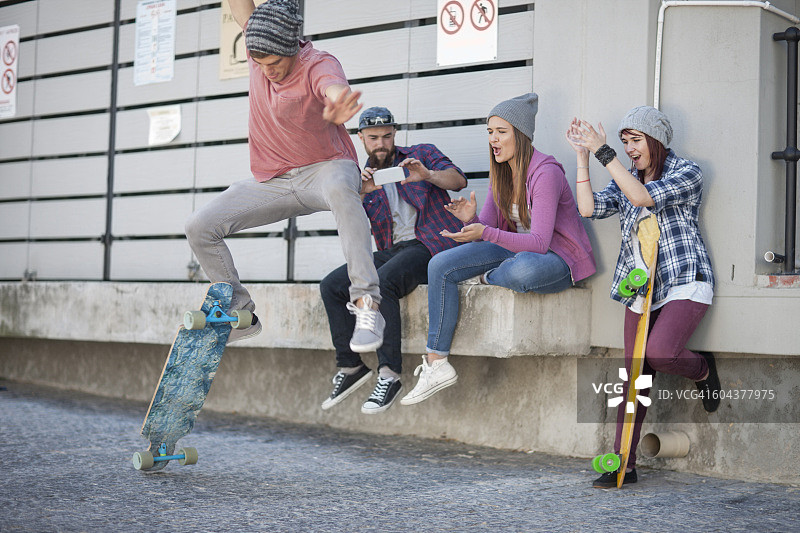 年轻人和朋友在玩滑板图片素材