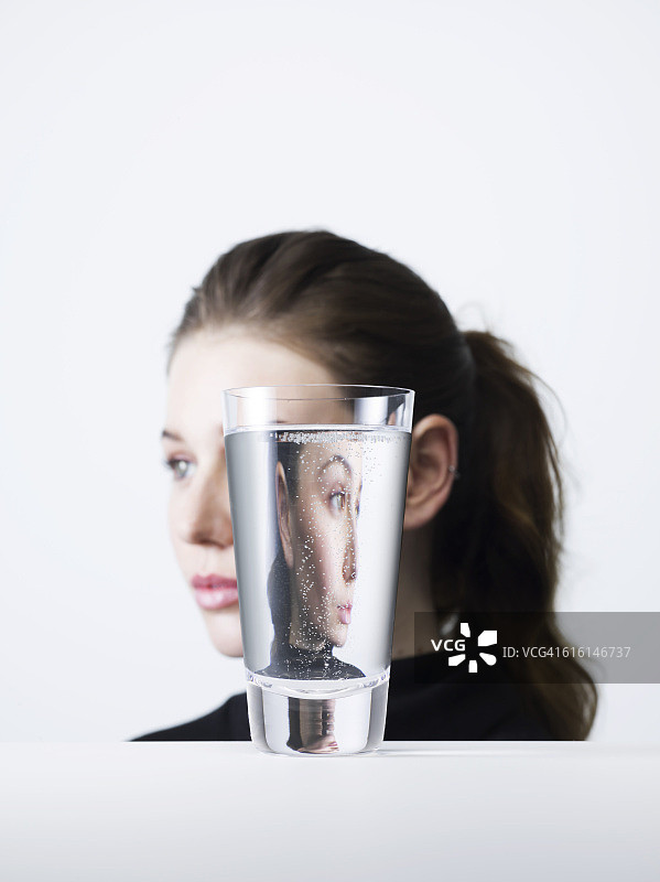 透过一杯水的女性肖像图片素材