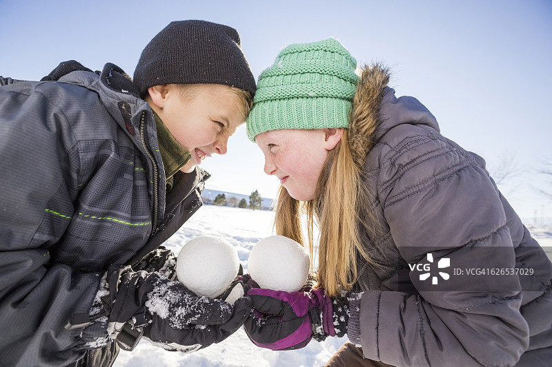 美国，犹他州，萨拉托加泉，儿童(8-9,10-11)拿着雪球和触摸额头图片素材