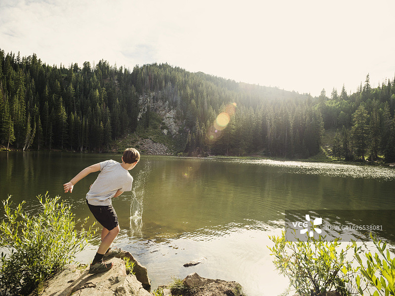 美国，犹他州，盐湖城，男孩(12-13)向湖中扔石头图片素材