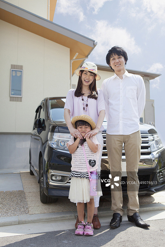 一个日本家庭站在汽车前图片素材