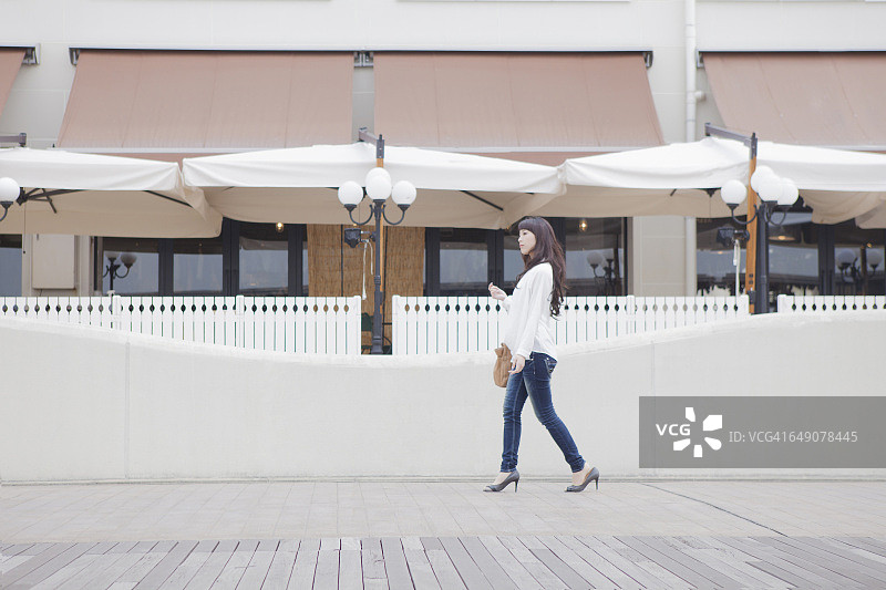 一个拎着包走路的日本女人图片素材