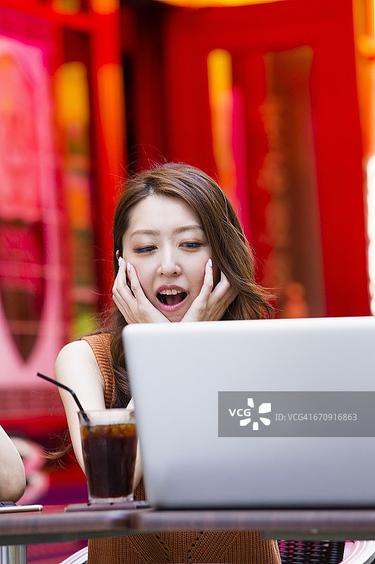 一位在户外咖啡馆里使用电脑的商业女性图片素材