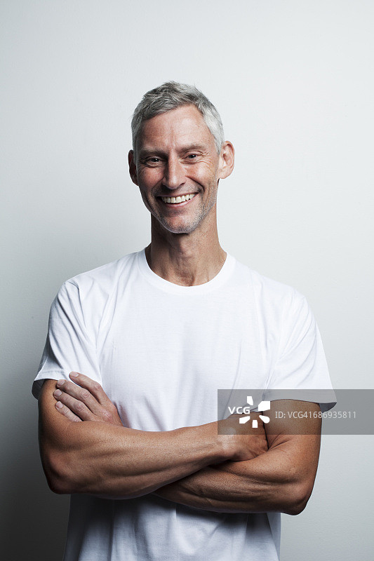 一个50多岁穿白t恤的男人的肖像图片素材