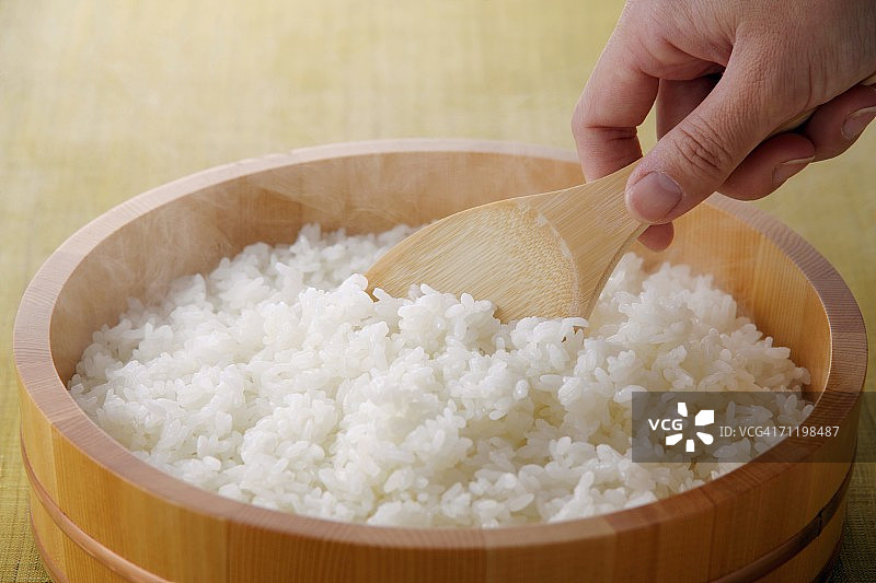 用勺子舀米饭的妇女图片素材