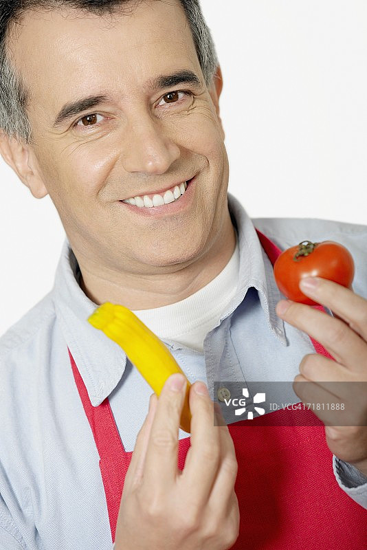 一个中年男子拿着番茄的肖像图片素材