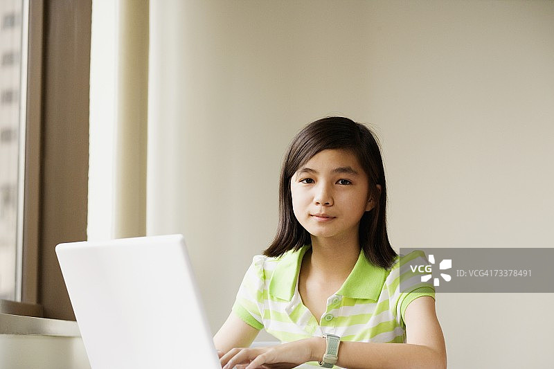 一个女孩用笔记本电脑的肖像图片素材