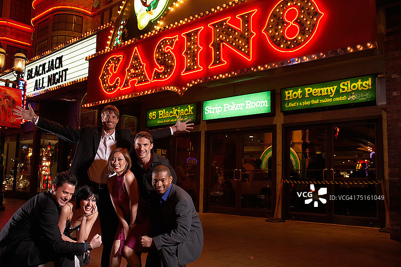 晚上在赌场前摆姿势的人们的合影，微笑着图片素材