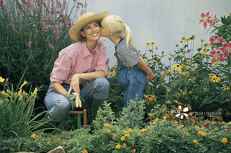 母亲和女儿在花园里接吻图片素材