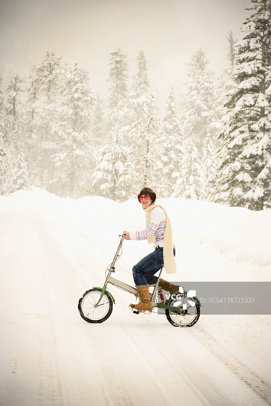 雪地里骑自行车的女人图片素材