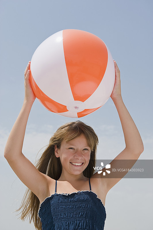 女孩把沙滩球举过头顶图片素材