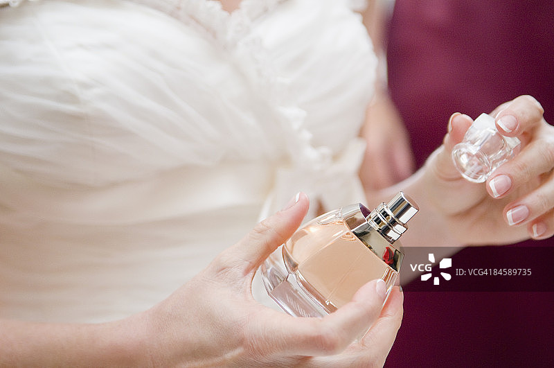 新娘取下香水瓶顶部的特写。图片素材