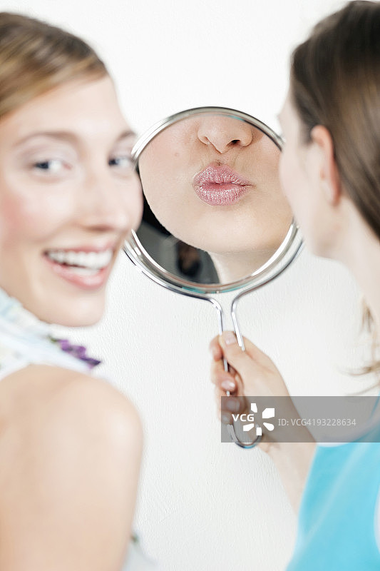年轻女子看着镜子图片素材