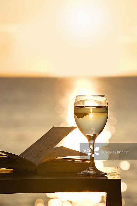 日落时分，一本书，一杯白葡萄酒图片素材