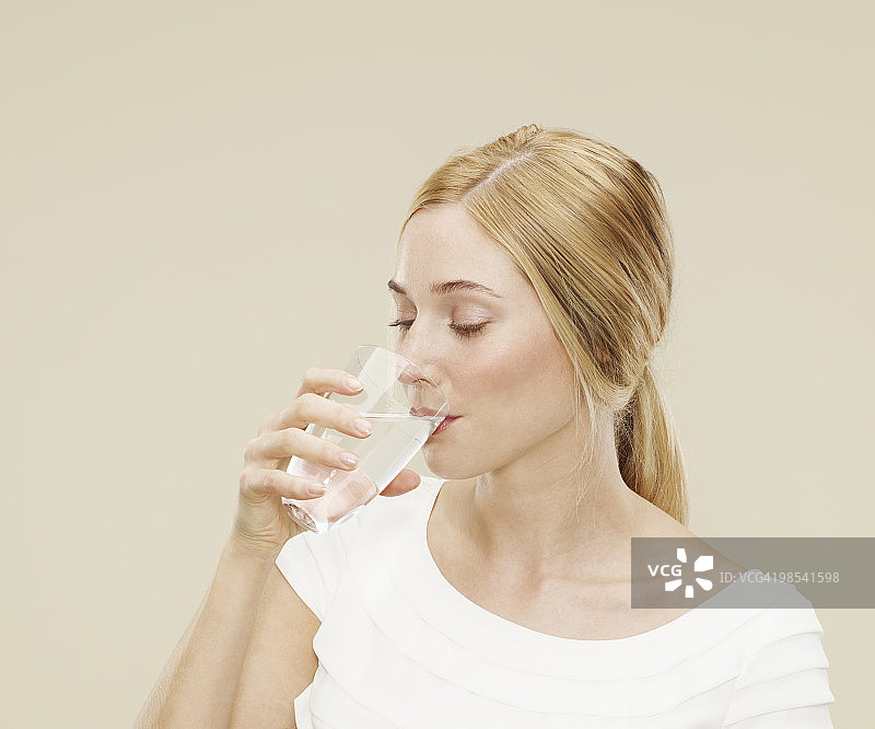 女人喝一杯水的肖像图片素材