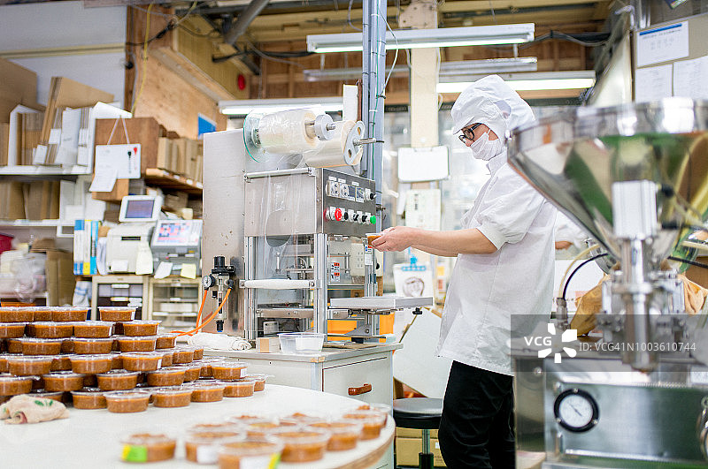 在食品加工厂包装食品的工人图片素材
