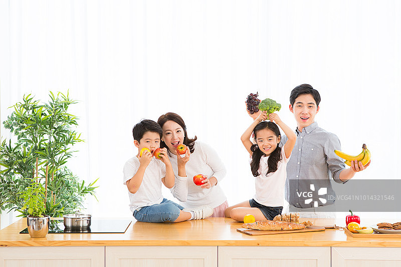 幸福的家庭在厨房里拿着水果和蔬菜图片素材