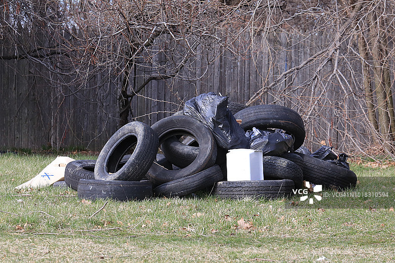 旧轮胎和垃圾倾倒在废弃的土地上图片素材