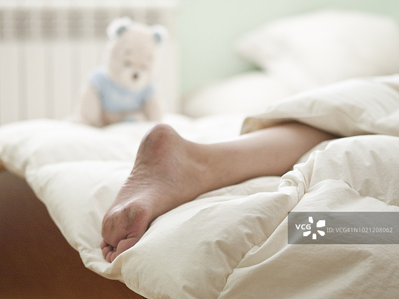 晨光下，白床上年轻女子的脏脚图片素材