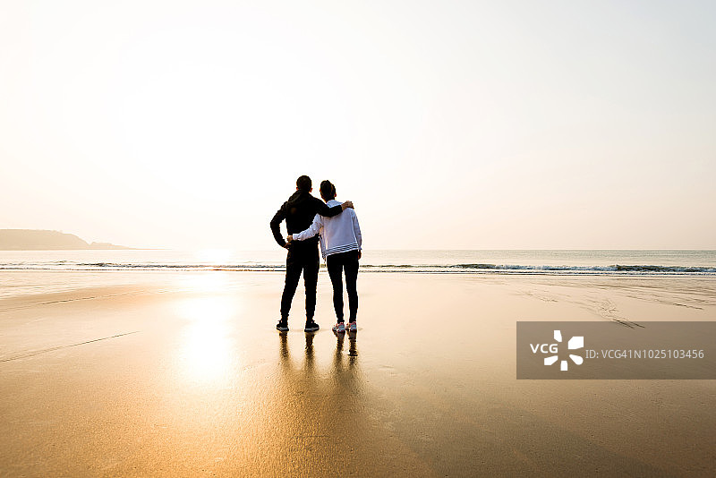 一对情侣手挽手站在海滩上图片素材