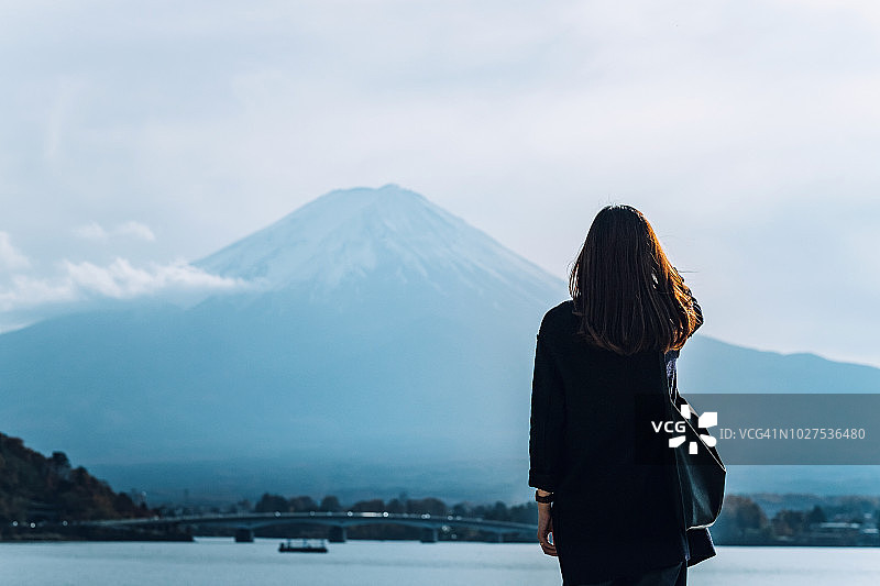 女人的后视图俯瞰富士山和川口湖对晴朗的天空图片素材