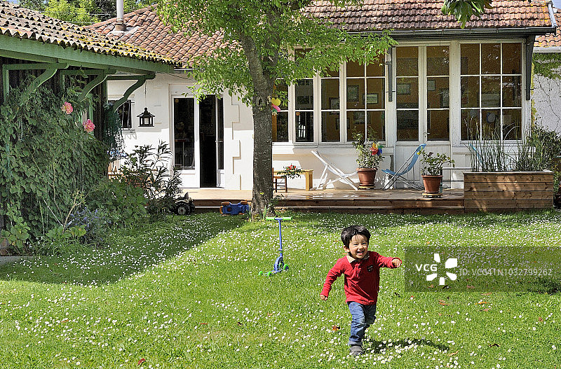 三岁小男孩在花园里奔跑图片素材