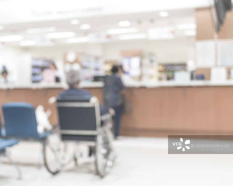模糊医疗背景的诊所服务柜台大堂与病人支付账单在收银台图片素材