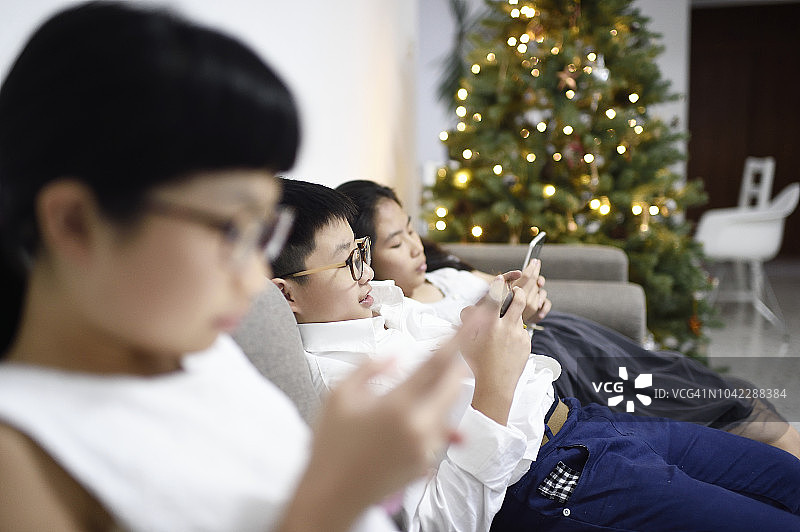 兄弟姐妹在圣诞节用手机发短信图片素材
