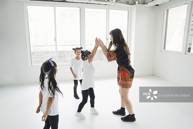 小嘻哈舞者为年轻女老师学习舞蹈。图片素材
