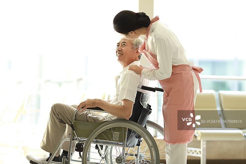 护理人员与轮椅上的病人交谈图片素材