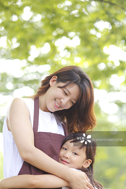 母亲和女儿在公园里拥抱的照片图片素材