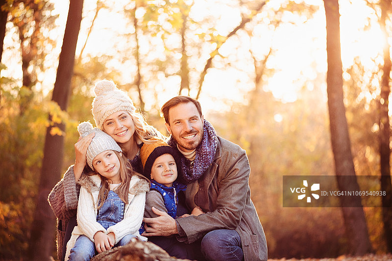 一个美丽的年轻幸福的家庭在秋天的天气图片素材