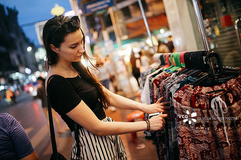 年轻女子旅行者浏览在曼谷街头市场的商店图片素材