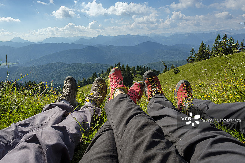 德国，巴伐利亚，布劳内克附近的Lenggries，徒步旅行者的腿在草地上的高山景观图片素材
