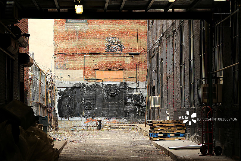 破旧的后巷与消防栓靠在工业墙。纽约图片素材