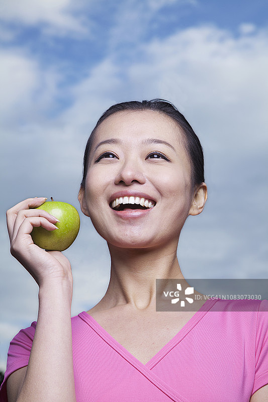 微笑的中国妇女拿着青苹果图片素材