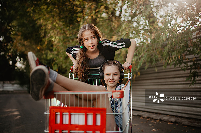 两个十几岁的女孩在玩购物车图片素材