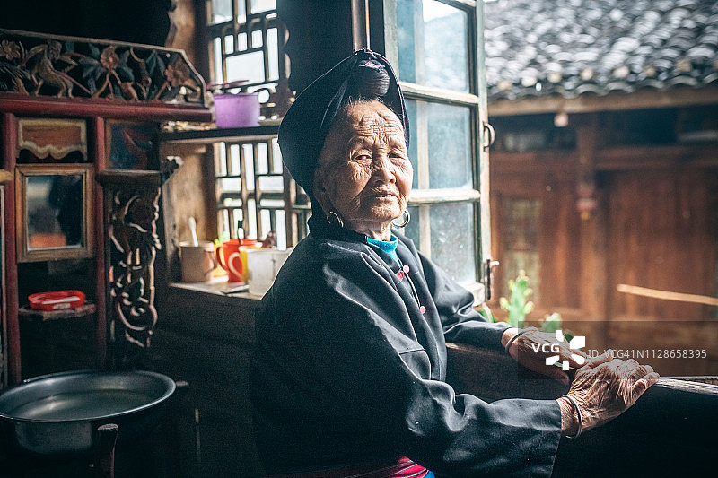 站在窗口的中国少数民族妇女图片素材