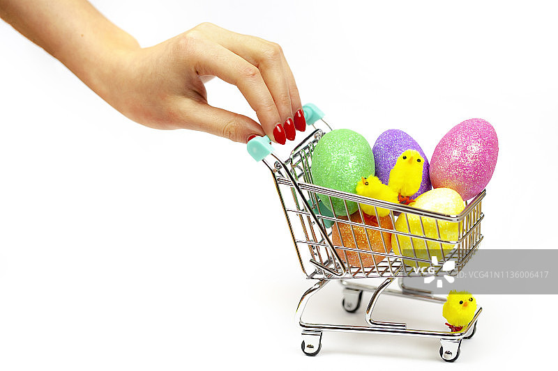 购物车里的彩色复活节彩蛋和一个女人推着它图片素材