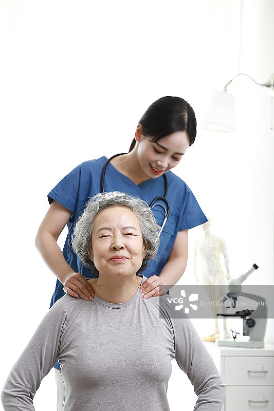 理疗师给老年妇女做肩部按摩图片素材