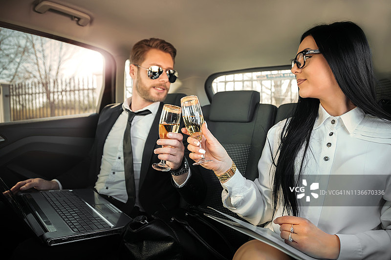 商务人士在长途商务旅行后在车里喝香槟图片素材