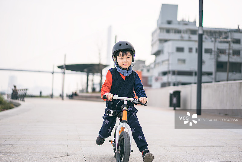 一个小男孩的肖像戴着运动头盔和骑自行车图片素材